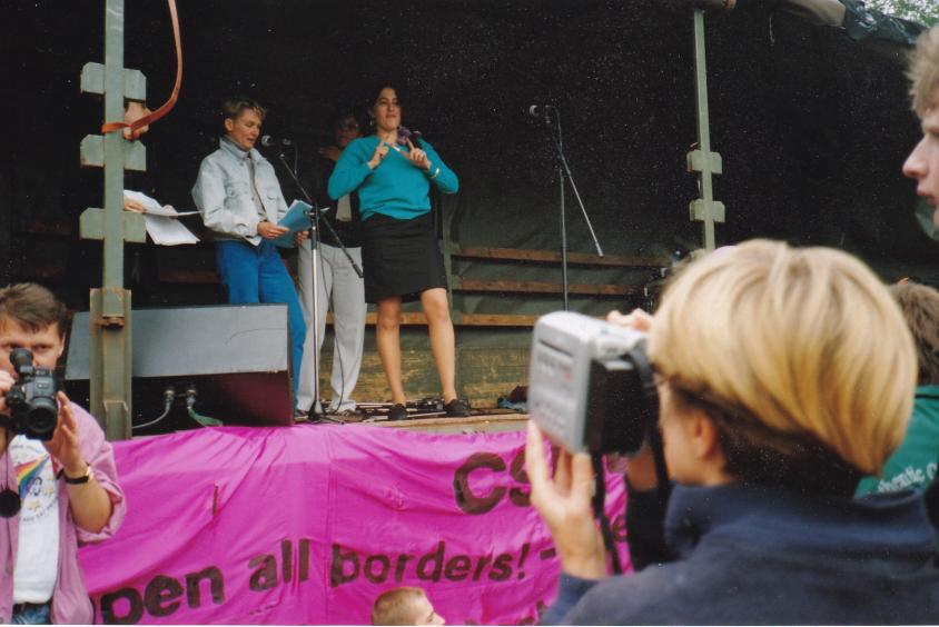 CSD Anfang der 90iger im Ostteil Berlins. Ilona Bubeck (am Mikrofon) hält eine Rede zu Kampf gegen Rassismus und Antisemitismus.