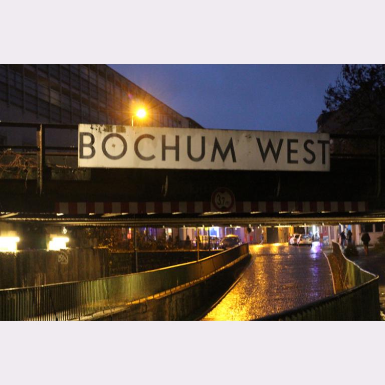 Foto einer Eisenbahnbrücke mit Schild Bochum West