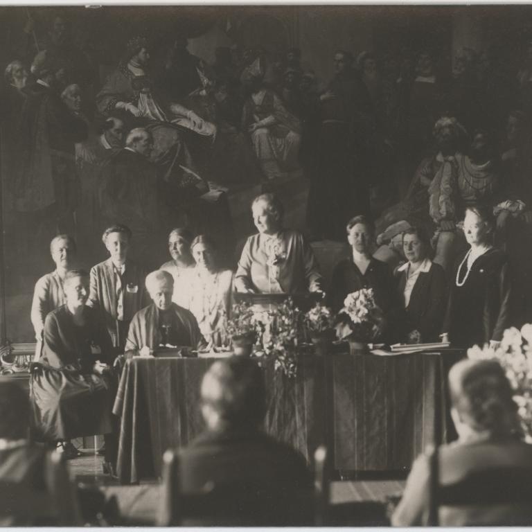 Generalversammlung des Deutschen Evangelischen Frauenbundes in Stralsund vom 08.-13.04.1927. In der ersten Reihe sind Selma von der Groeben (2. v. links), Paula Mueller-Otfried (am Pult stehend), Adelheid von Bennigsen und Auguste Jorns zu sehen.